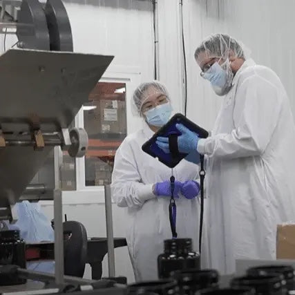 Quality team members reviewing production information beside manufacturing equipment